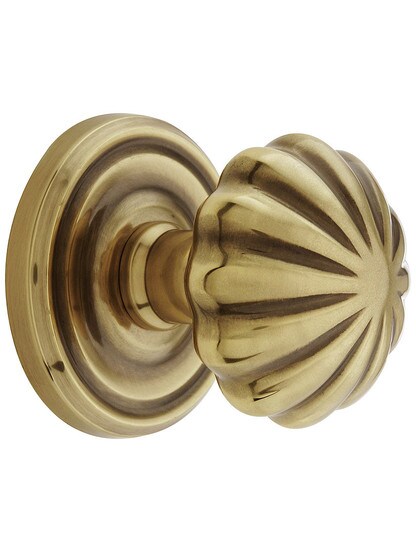 Classic Rosette Set With Fluted Brass Knobs in Antique Brass.